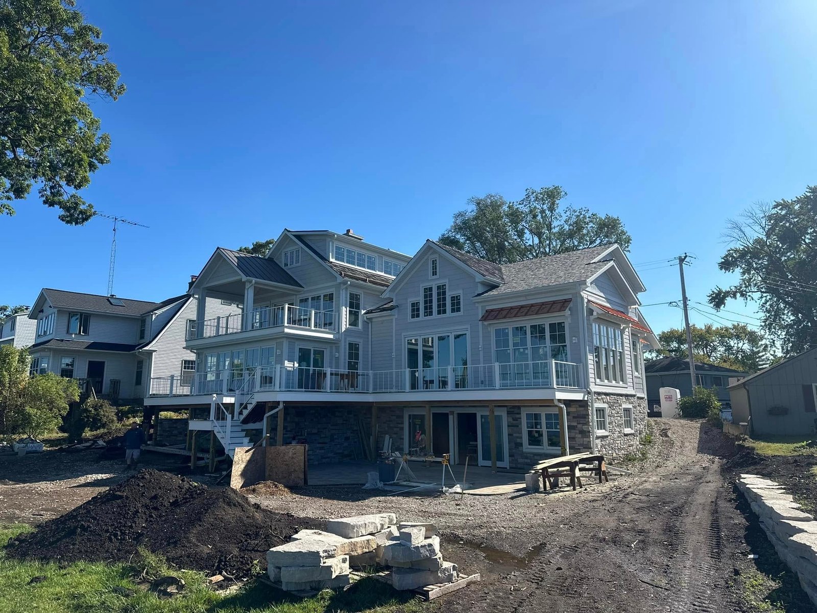 Before: the Burlington lakehouse mid-build, stone set and the grade still open dirt