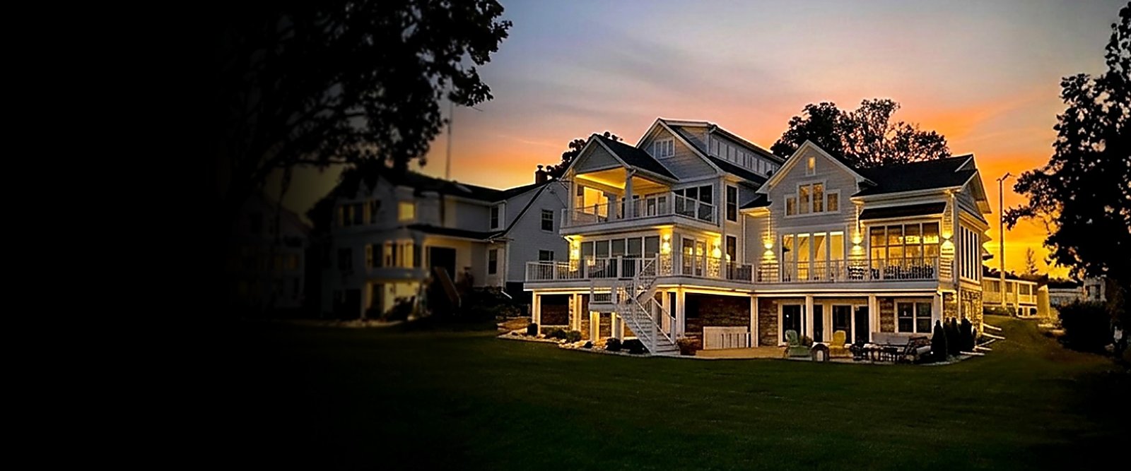 After: the finished Burlington lakehouse glowing at sunset over the lawn