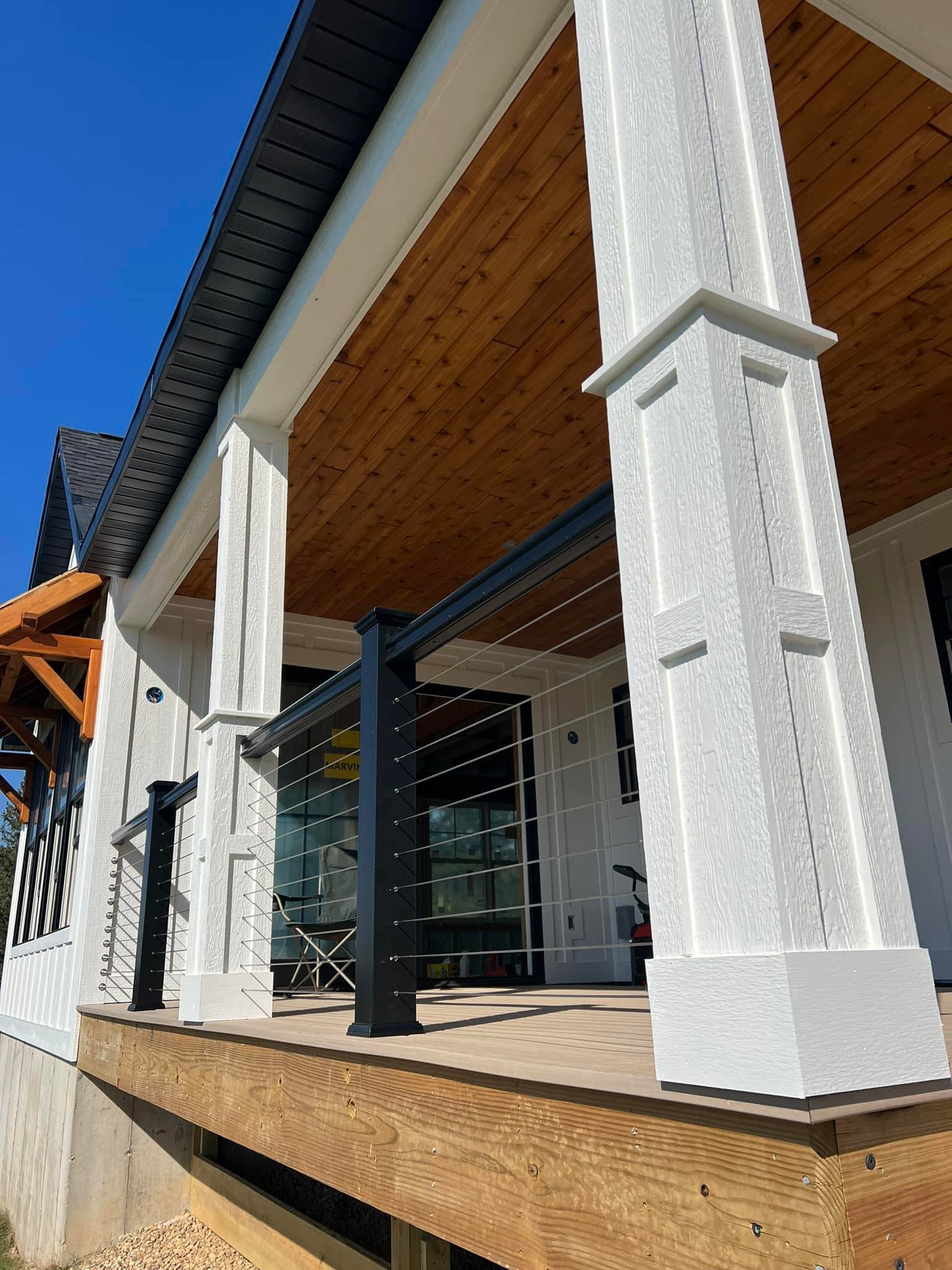 Finished porch colonnade with cedar ceiling and cable rail