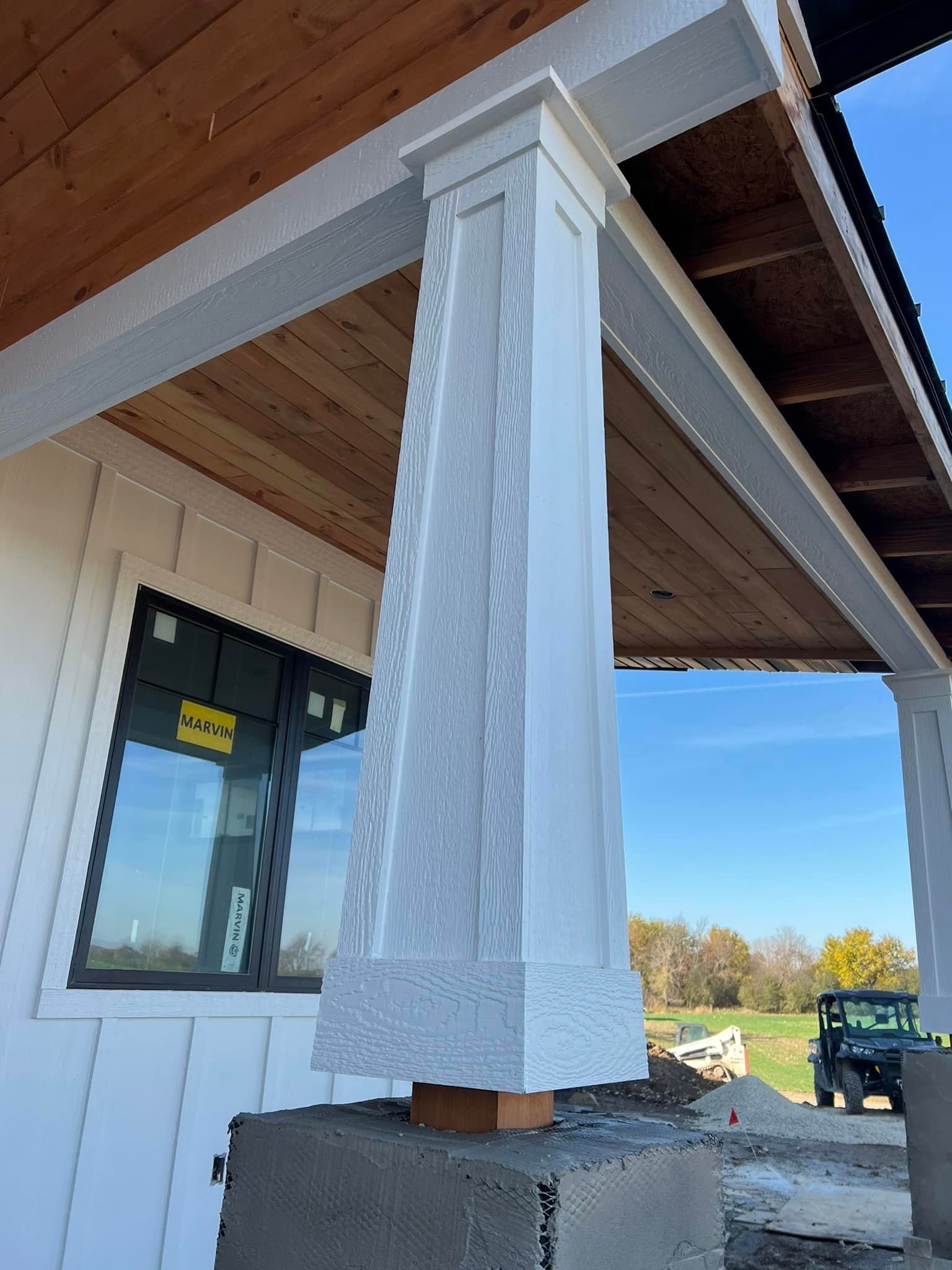 Tapered porch column mid-build with cedar ceiling above