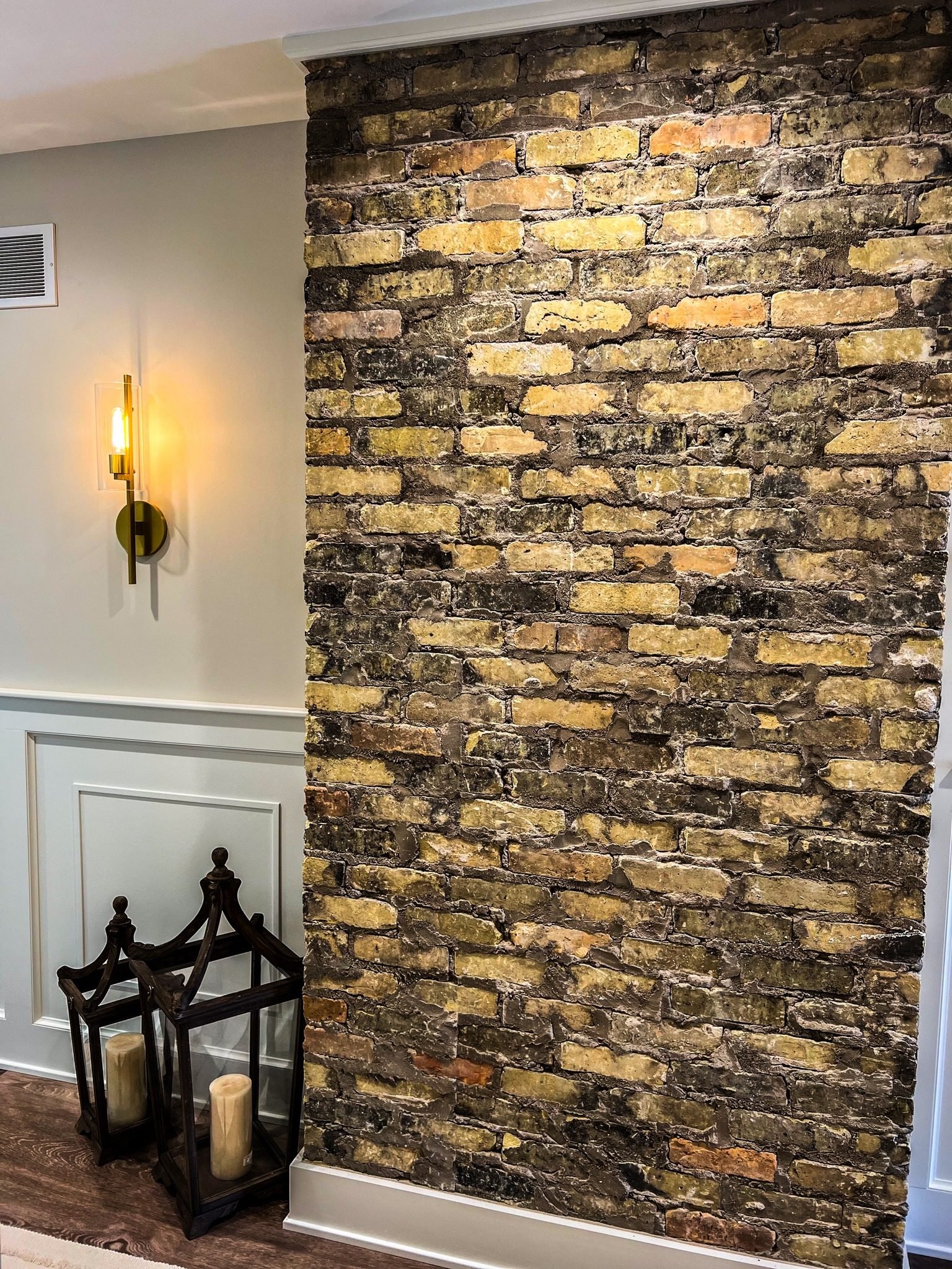 Interior accent wall of reclaimed Chicago brick with wainscoting and sconce