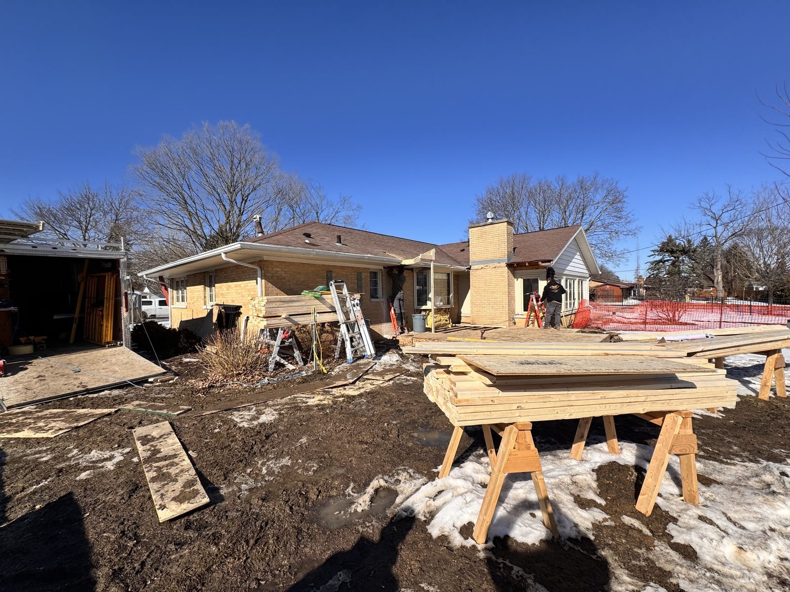 A Monien Construction addition in Delavan under construction, walls framed and sheathed under a clear winter sky