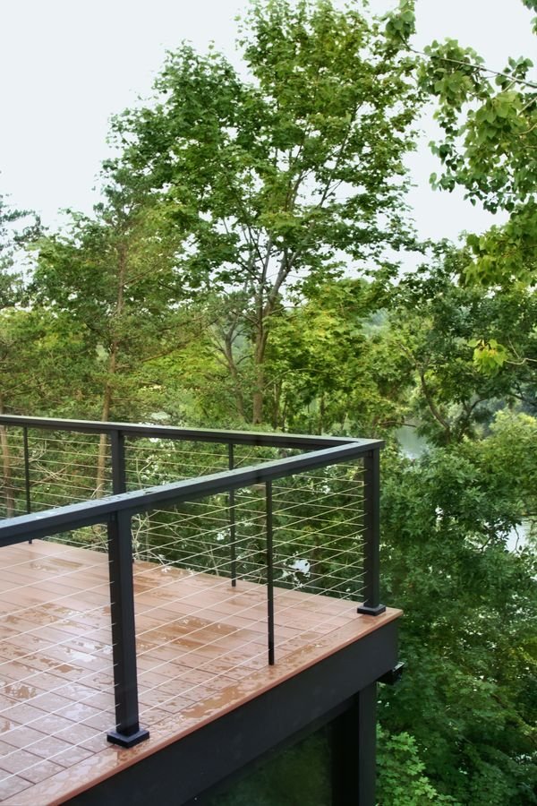 Deck with cable rail extending into the treetops above the lake